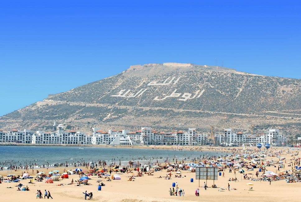 Sunny winter day on Agadir beach with palm trees and a clear blue sky